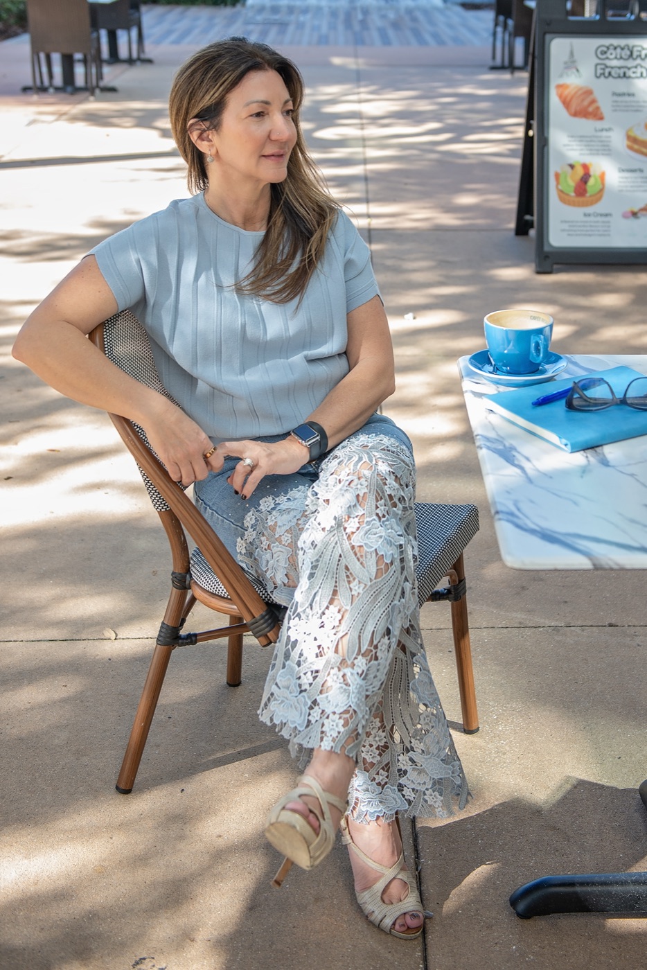 Carrie relaxed at a cafe, hand in her hair