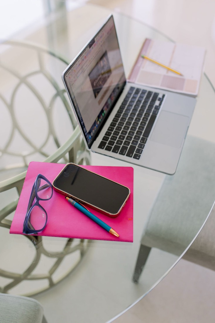 Laptop, notebook and phone on a glass table