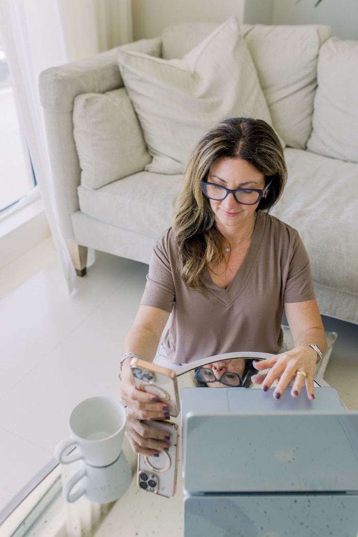 Carrie in glasses at her laptop in the living room