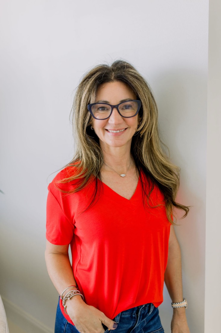 Carrie in glasses and a red top, smiling